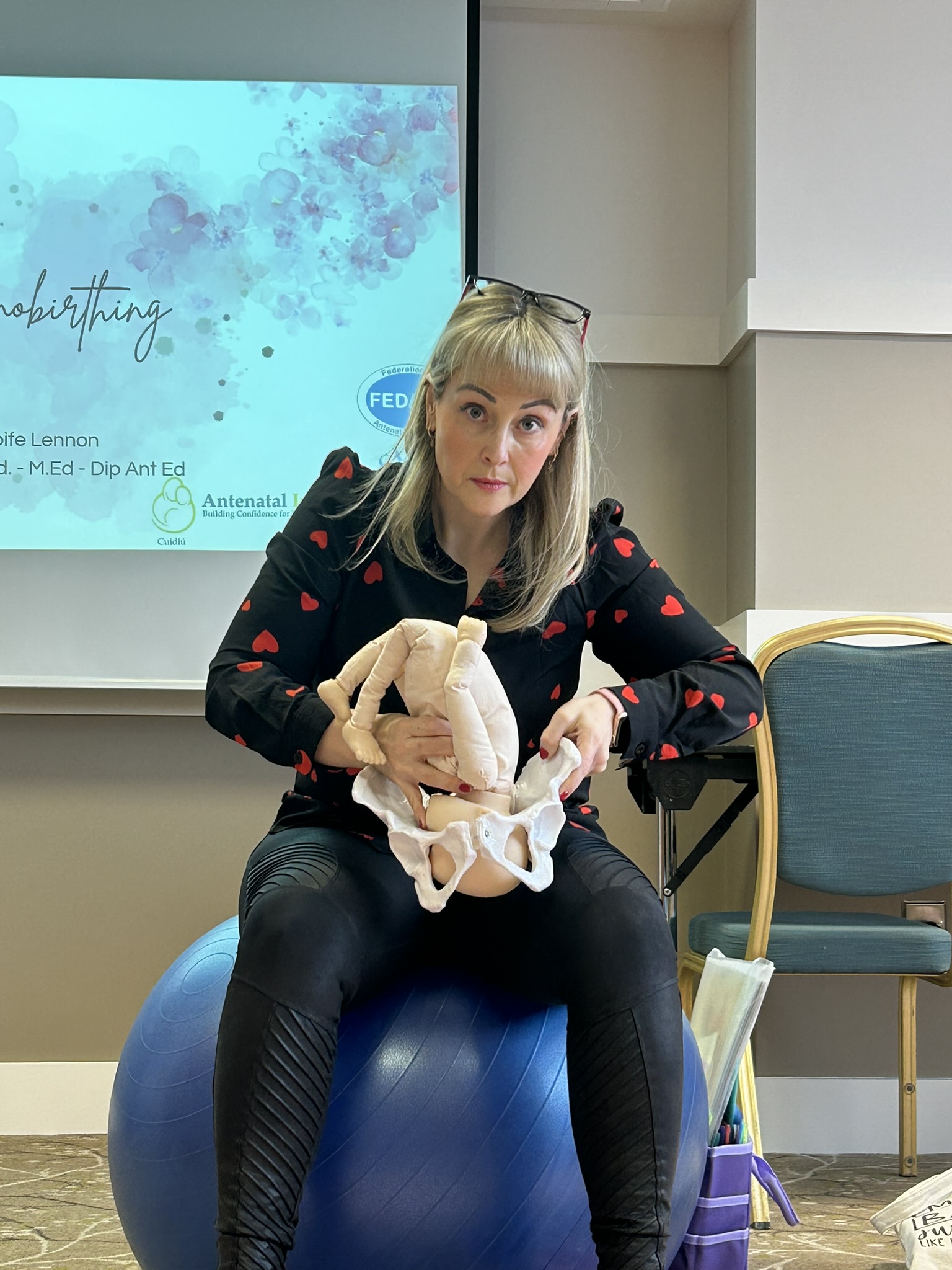Me, looking very serious, demonstrating how the baby moves through the pelvis